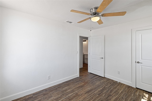 unfurnished bedroom with visible vents, dark wood finished floors, baseboards, and ceiling fan