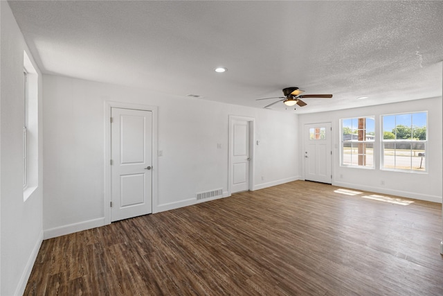 spare room featuring wood finished floors, visible vents, and baseboards