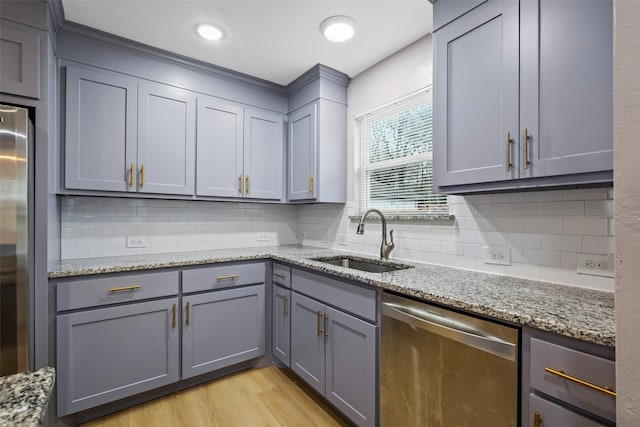 kitchen with appliances with stainless steel finishes, a sink, and gray cabinetry