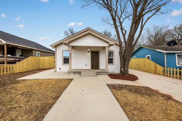 bungalow-style house with covered porch and fence