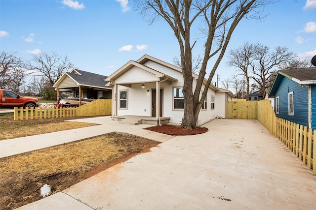 bungalow with concrete driveway, fence, and a gate