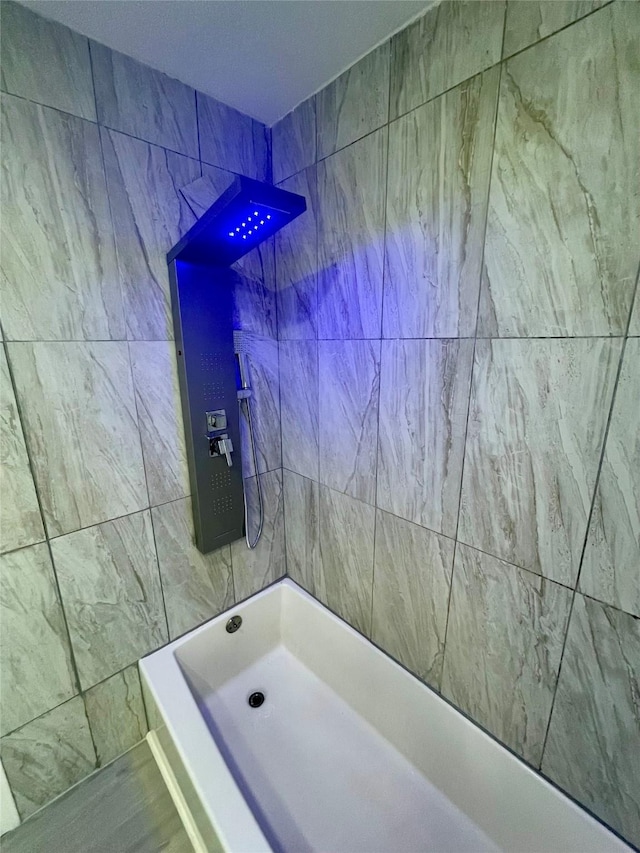 full bath featuring tile walls and walk in shower