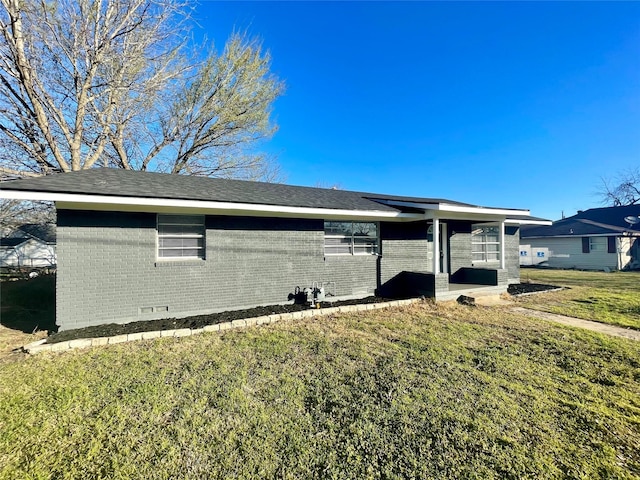 309 E Travis St, Italy, TX 76651 - view of home's exterior featuring brick siding and a yard
