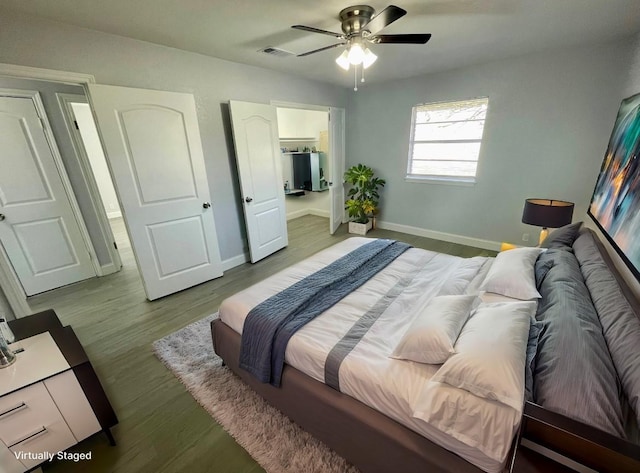 bedroom with visible vents, ceiling fan, baseboards, and wood finished floors