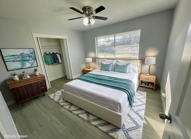 bedroom with a closet, wood finished floors, baseboards, and ceiling fan