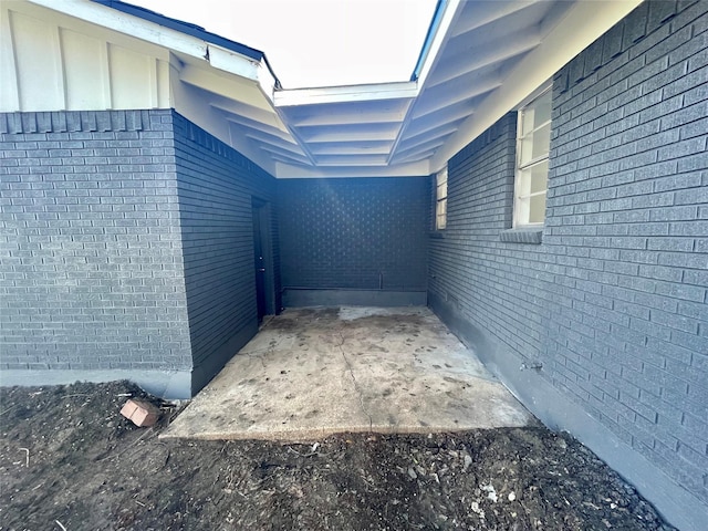 view of side of home featuring brick siding and board and batten siding