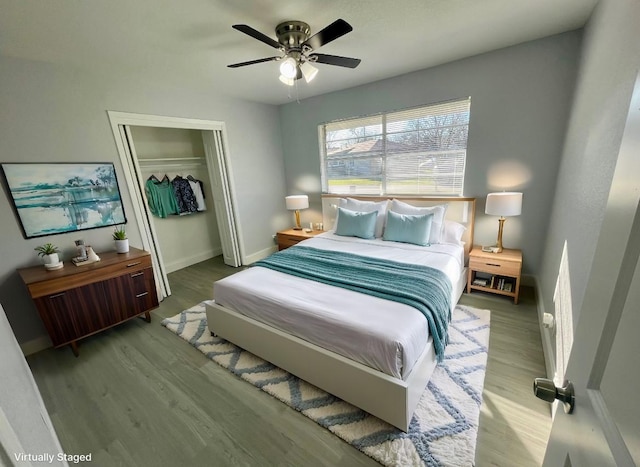 bedroom featuring ceiling fan, a closet, wood finished floors, and baseboards