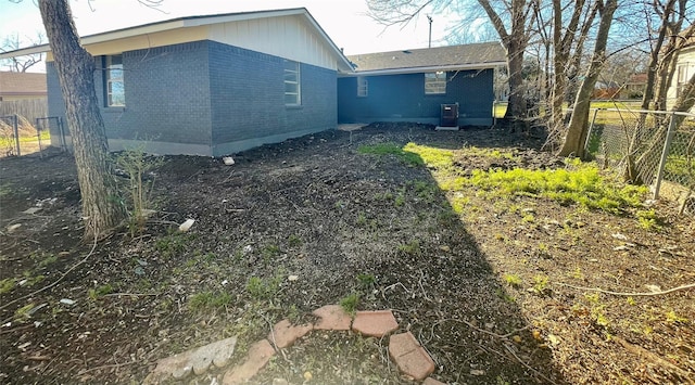 exterior space featuring fence and brick siding