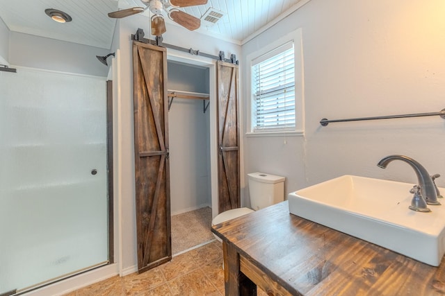 bathroom with visible vents, toilet, ceiling fan, a shower stall, and a sink