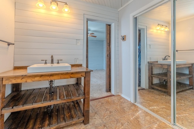 bathroom with a sink and wood walls