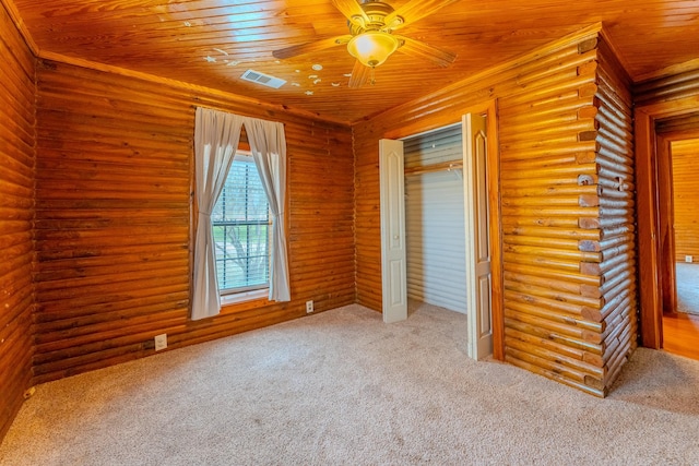 unfurnished bedroom with rustic walls, visible vents, wood ceiling, carpet, and a closet