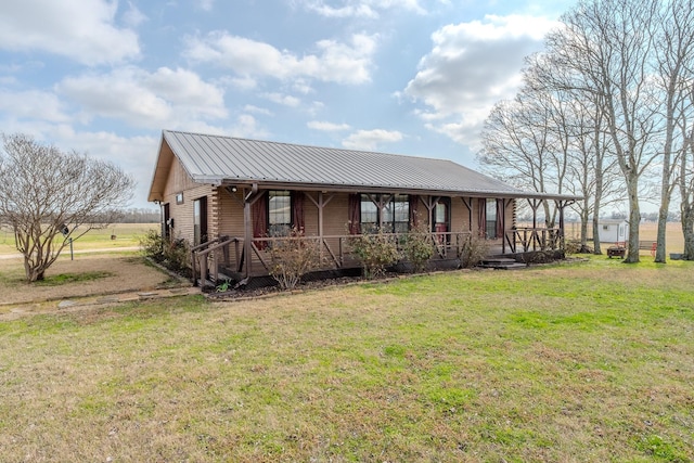 view of front of house featuring covered porch, dirt driveway, metal roof, and a front yard