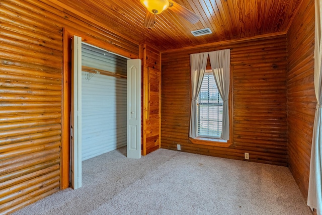 unfurnished bedroom with rustic walls, visible vents, wood ceiling, carpet flooring, and a closet