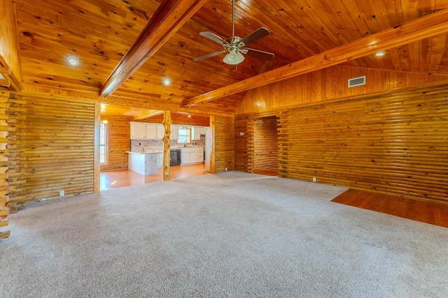 unfurnished living room featuring vaulted ceiling with beams, light colored carpet, visible vents, wood ceiling, and wooden walls