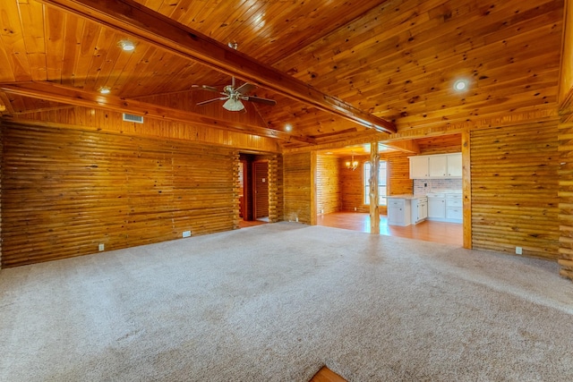 unfurnished living room featuring lofted ceiling with beams, wooden ceiling, light carpet, wood walls, and a ceiling fan