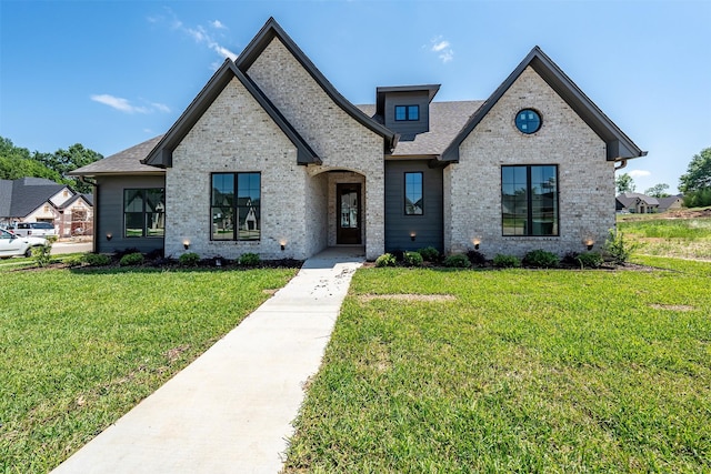 4618 Flat Creek Cv, Tyler, TX 75703 - french country style house featuring a front yard, brick siding, and roof with shingles