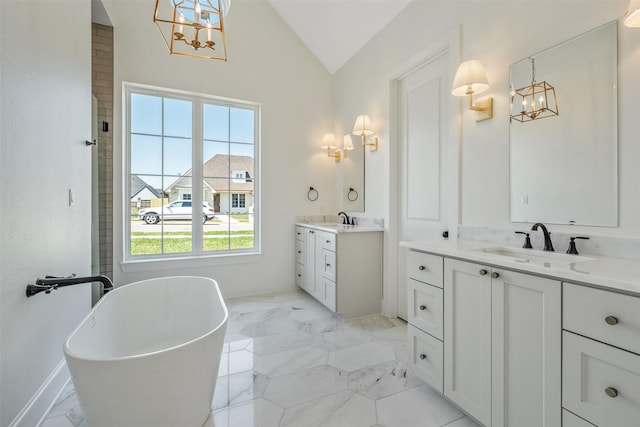 4618 Flat Creek Cv, Tyler, TX 75703 - full bath featuring a chandelier, marble finish floors, lofted ceiling, two vanities, and a soaking tub