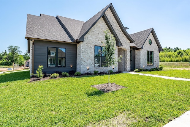 4618 Flat Creek Cv, Tyler, TX 75703 - french provincial home featuring a front yard, roof with shingles, and brick siding