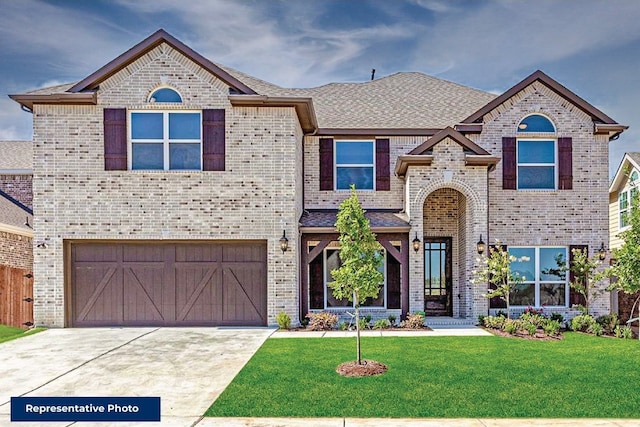 view of front of home with a garage, concrete driveway, a front lawn, and brick siding