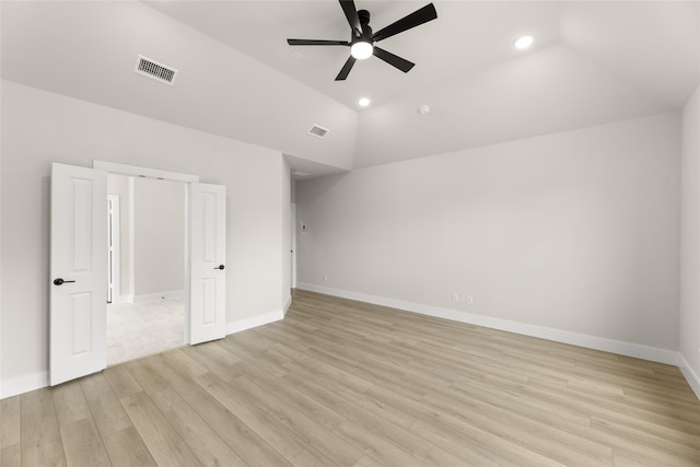 unfurnished bedroom featuring light wood-style floors, baseboards, vaulted ceiling, and visible vents