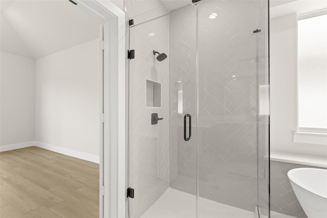 full bath with a freestanding bath, baseboards, a stall shower, and wood finished floors