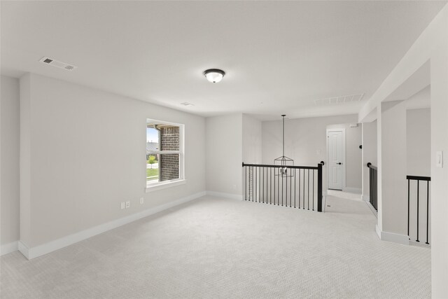 unfurnished room featuring light carpet, visible vents, and baseboards