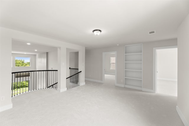 unfurnished room with visible vents, baseboards, and carpet floors
