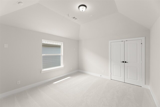 interior space with visible vents, baseboards, a closet, carpet, and lofted ceiling