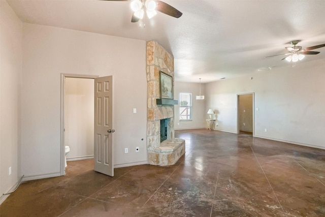 unfurnished living room with baseboards, ceiling fan, a fireplace, and concrete floors