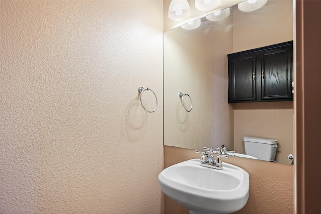 half bath with toilet and a sink