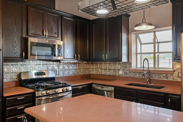kitchen featuring a sink, appliances with stainless steel finishes, backsplash, and light countertops