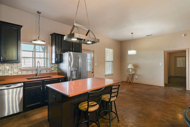 kitchen featuring visible vents, a sink, decorative backsplash, appliances with stainless steel finishes, and dark cabinets