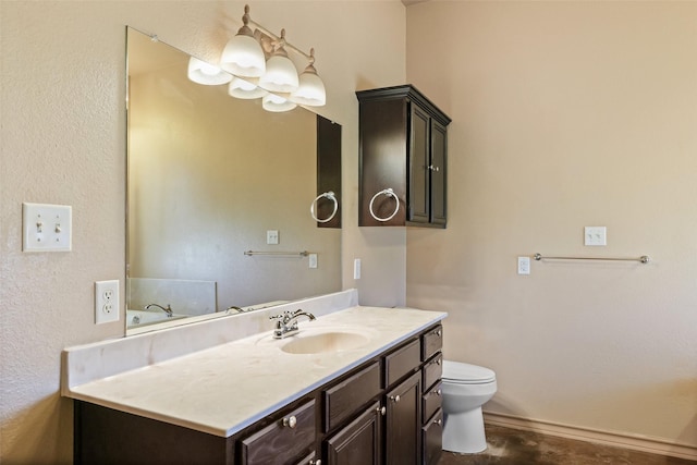 bathroom with toilet, vanity, and baseboards