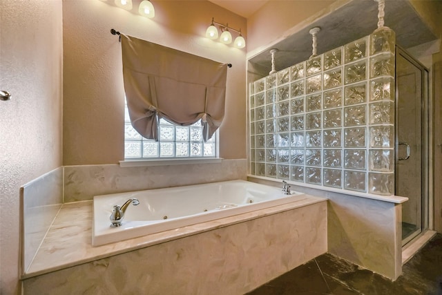 full bath with a textured wall, a tub with jets, and a stall shower