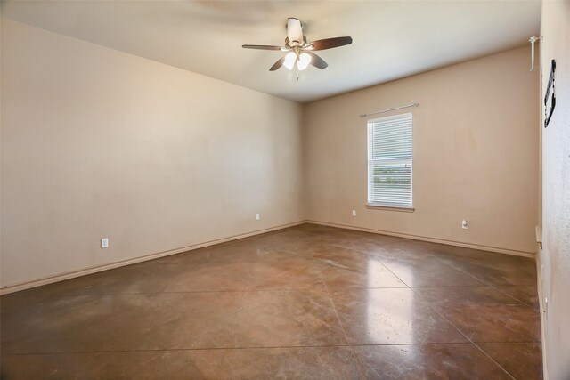 spare room featuring baseboards, a ceiling fan, and concrete floors