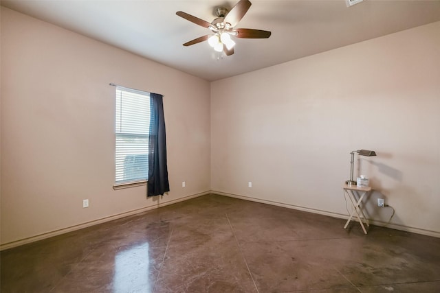 spare room with ceiling fan, concrete floors, and baseboards