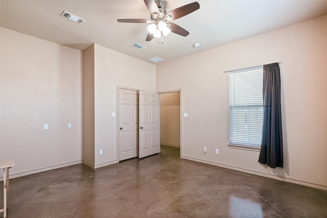 unfurnished bedroom featuring baseboards, visible vents, finished concrete flooring, and a ceiling fan