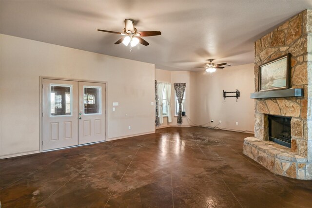 unfurnished living room with a fireplace, baseboards, french doors, and ceiling fan