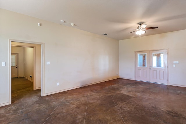 spare room with visible vents, a ceiling fan, and baseboards