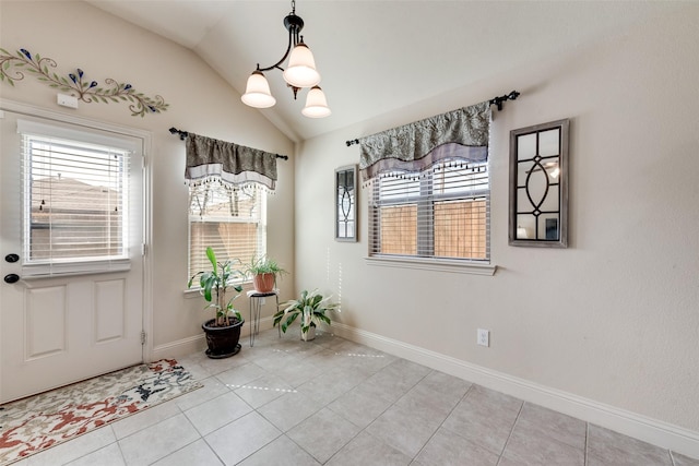 interior space featuring a chandelier, lofted ceiling, light tile patterned flooring, and baseboards