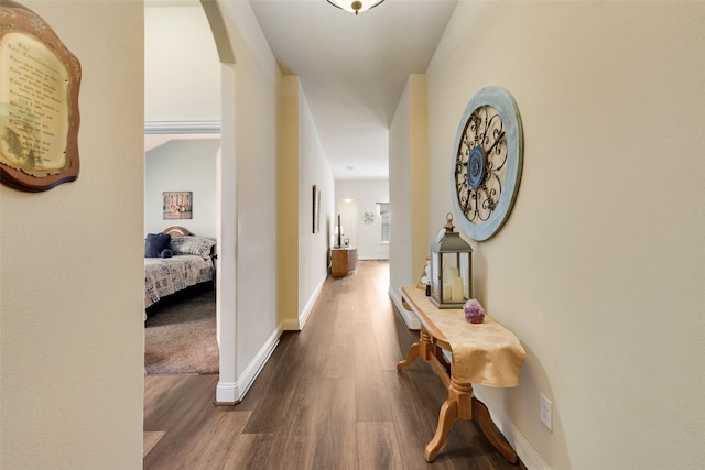 hallway featuring dark wood-style floors and baseboards