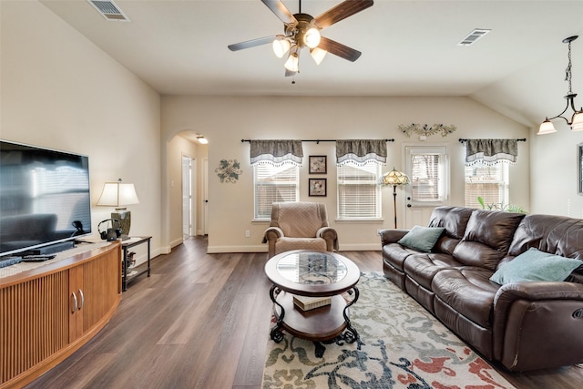 living room featuring arched walkways, wood finished floors, and visible vents