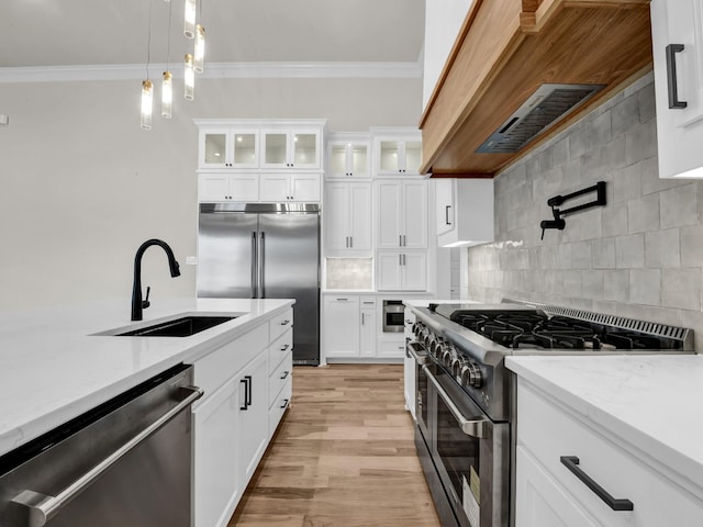 kitchen featuring high quality appliances, ornamental molding, backsplash, and a sink