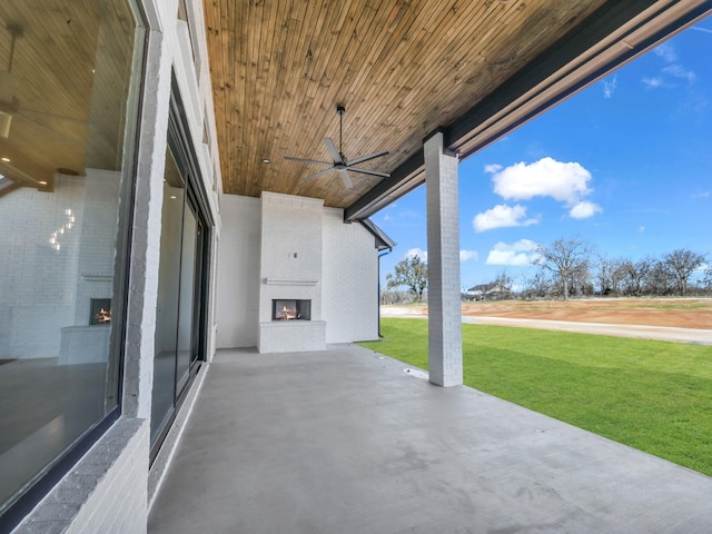 view of patio / terrace featuring an outdoor brick fireplace and a ceiling fan