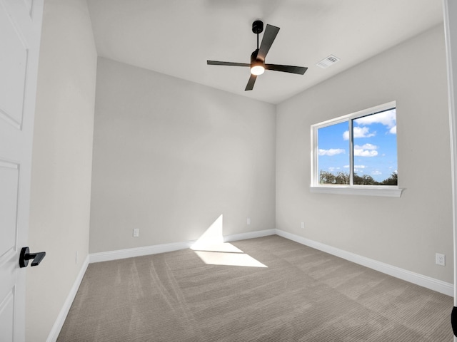 carpeted empty room with baseboards, visible vents, and ceiling fan