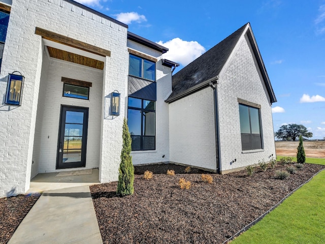 entrance to property featuring brick siding