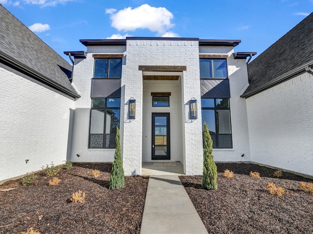 view of exterior entry with brick siding