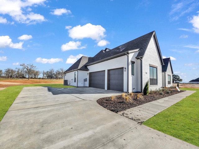 view of home's exterior featuring a garage, concrete driveway, a lawn, and roof with shingles