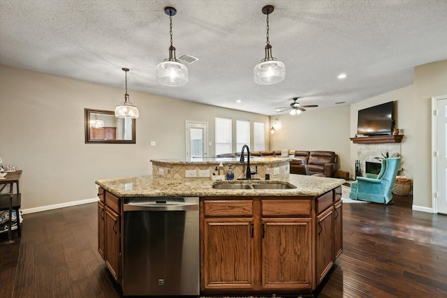 kitchen with dark wood finished floors, decorative light fixtures, a sink, and stainless steel dishwasher