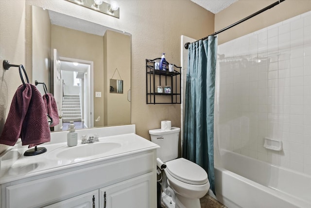 bathroom with toilet, vanity, shower / bath combination with curtain, and a textured wall